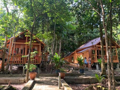 uma casa de madeira com pessoas à frente dela em The Wavy Sailor Bungalow's em Koh Rong Island