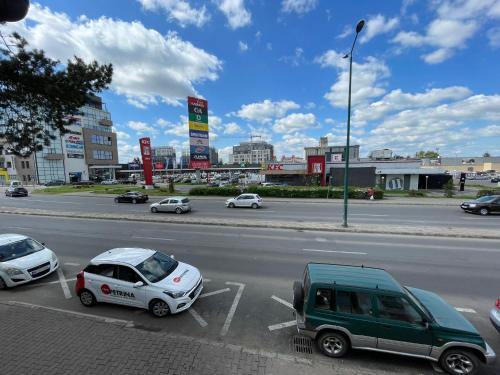 twee auto's geparkeerd op een parkeerplaats in een stadsstraat bij EVA's Rooms in Târgu-Mureş