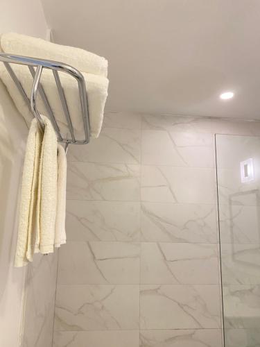 La salle de bains est pourvue d'une douche et de serviettes blanches. dans l'établissement Lovely Apartment #3 in Venetian Site, à Turtle Cove