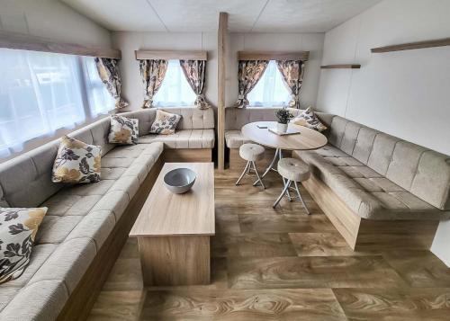 a living room with a long couch and a table at Lemonford Caravan Park in Bickington