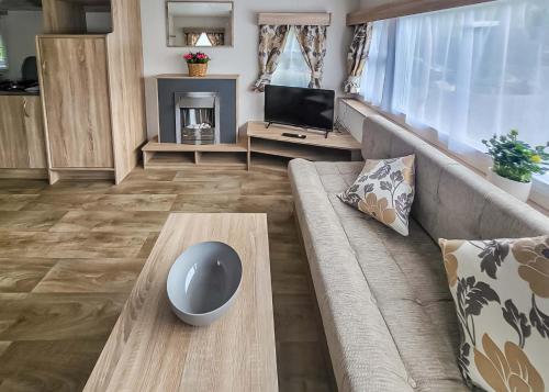 a living room with a couch and a tv at Lemonford Caravan Park in Bickington