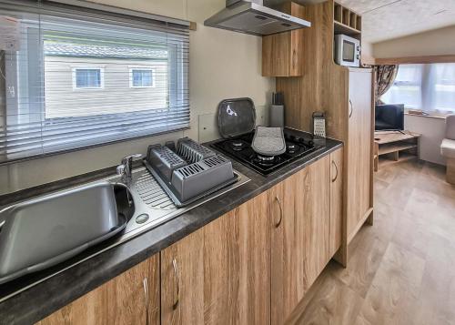 a kitchen with a sink and a counter top at Lemonford Caravan Park in Bickington