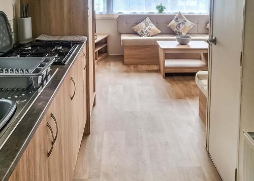 a kitchen with a stove and a couch in a room at Lemonford Caravan Park in Bickington