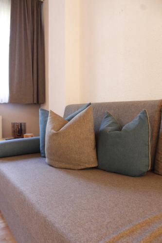 a couch with three pillows sitting on it at Haus Schröcker in Gaschurn