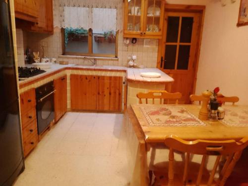 a kitchen with a wooden table and a table and a table and chairs at Terraced house with stunning view close to Mdina in Rabat