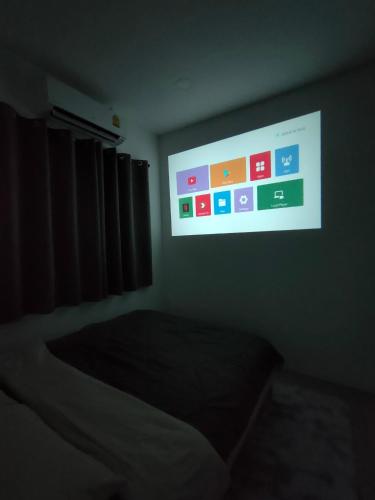 a tv screen in a dark room with a bed at Janis Home in Ban Noi Pho Kham