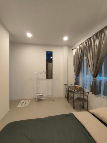 Schlafzimmer mit einem Bett, einem Tisch und einem Fenster in der Unterkunft Janis Home in Ban Noi Pho Kham