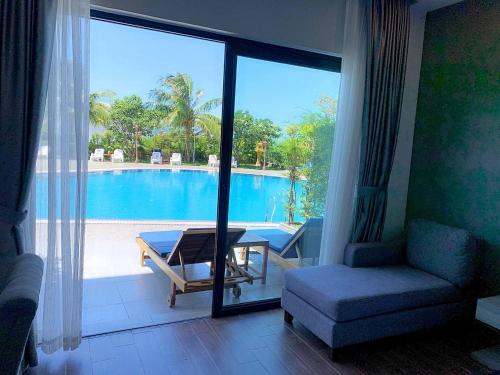 a living room with a view of a swimming pool at KEP BAY HOTEL & RESORT in Kep