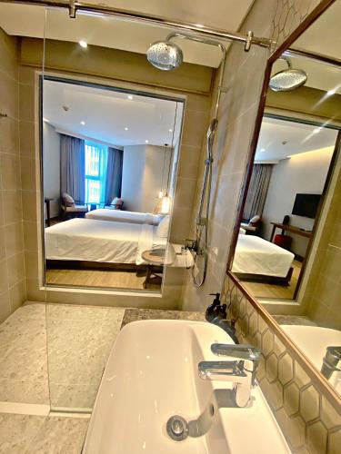 a bathroom with a sink and a large mirror at Apec MANDALA CHAM BAY MUI NE SPA RESORT AND CONDOTEL in Ấp Thiẹn Ái