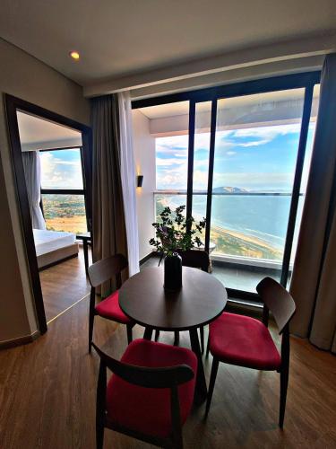 a room with a table and chairs and a large window at Apec MANDALA CHAM BAY MUI NE SPA RESORT AND CONDOTEL in Ấp Thiẹn Ái