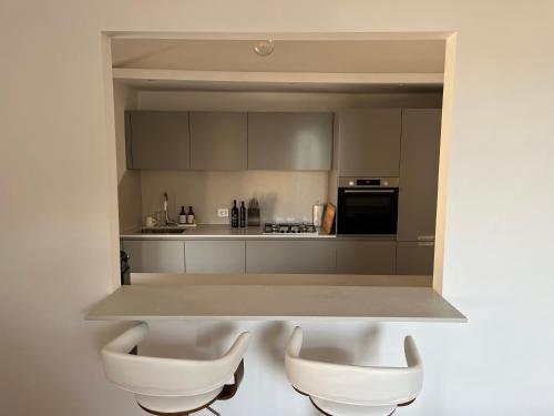 a kitchen with two white chairs in the middle at Appartamento con terrazzo in Orvieto