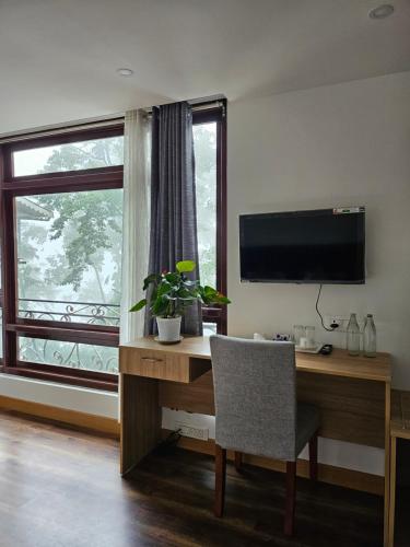 Una televisión o centro de entretenimiento en Shanol Residency