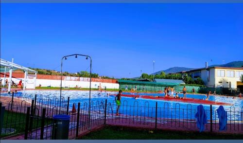 una gran piscina con gente en el agua en Casa RuralRut en El Tiemblo, zona de baño natural muy cercana y a solo 50 min de Madrid, en El Tiemblo