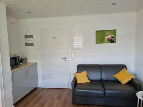 a living room with a black couch and a kitchen at Ferienhaus Am Reilsbach in Cochem