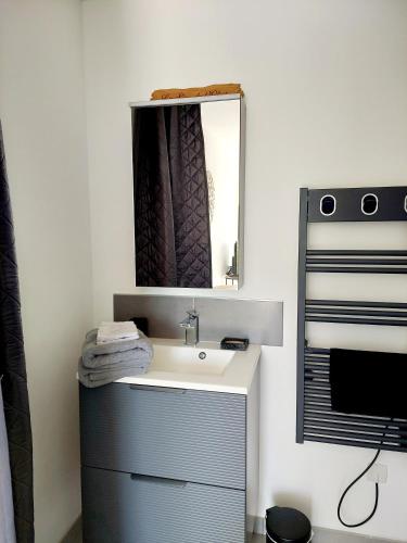 une salle de bain avec un lavabo et un miroir dans l'établissement La Sève de l'Olivier, à Amblans-et-Velotte