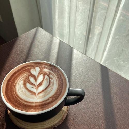 a cup of coffee sitting on a table at Green Hotel - Chiayi in Chiayi City
