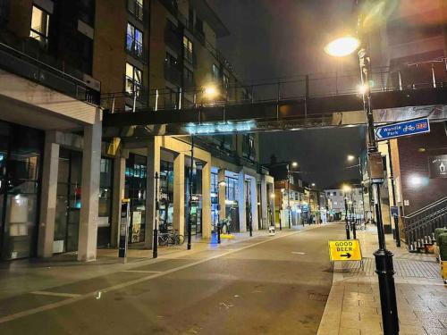 an empty city street at night with a street light at Lovely CroydonCentral apartment in Croydon