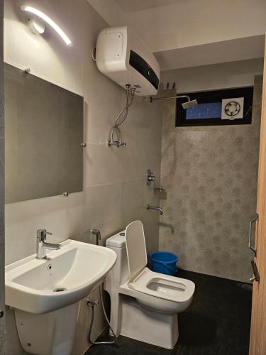 a bathroom with a sink and a toilet and a mirror at Shanol Residency in Gangtok