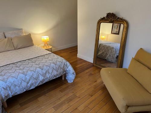 a bedroom with a bed and a mirror and a couch at 3 Cailloux in Amiens