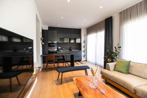 a living room with a couch and a table at AEGLI Central Luxury Apartment in Alexandroupoli