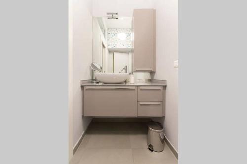 uma casa de banho com um lavatório e um espelho em Luxury Flat Design District em Milão