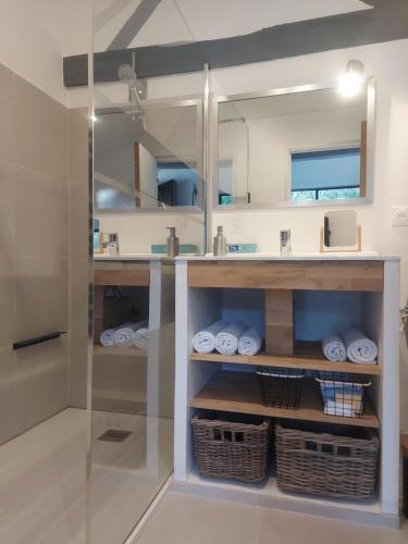 ein Bad mit einem Waschbecken und einem Spiegel in der Unterkunft Gîte, Le Séchoir à Lin demeure de charme 