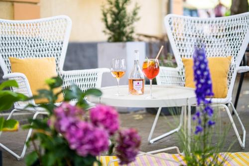 una mesa con dos copas de vino y flores en Neptun Badacsony, en Badacsonytomaj