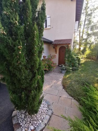 une maison avec un pin et une passerelle en pierre dans l'établissement La Moderne, à Saint-Prim