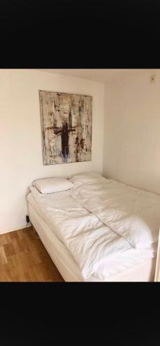 een bed in een kamer met een schilderij aan de muur bij Lottas Lovely Loft in Bunkeflostrand