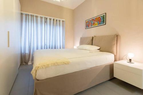 um quarto com uma cama grande e uma janela em Luxury Flat Design District em Milão