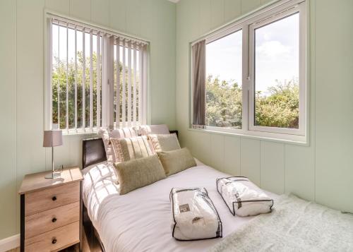 um quarto com uma cama e duas janelas em Calvesland Hideaway em Manorbier