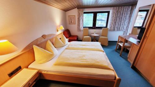 ヴェステンドルフにあるApartment Neuhaushofのベッドとデスクが備わる小さな客室です。