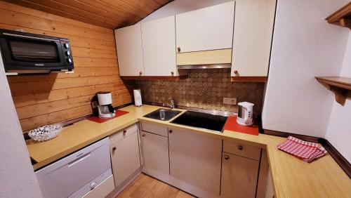 a small kitchen with a sink and a microwave at Apartment Neuhaushof in Westendorf