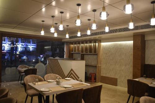 a dining room with tables and chairs and lights at HOTEL EDEN GARDEN in Āsansol