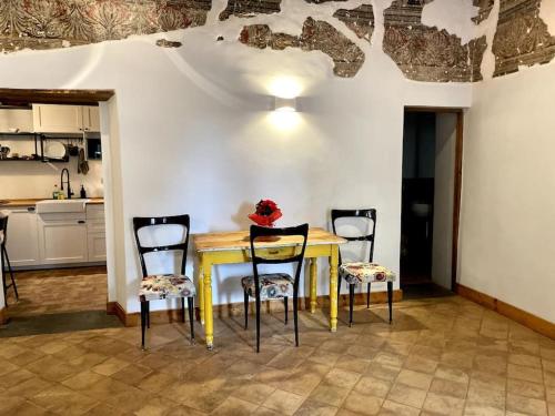 une table jaune avec quatre chaises dans une cuisine dans l'établissement Bella Casa Affrescata, à Orvieto