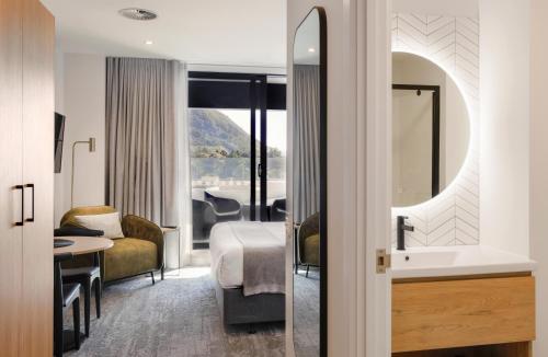 a hotel room with a sink and a bedroom at Quest Mt Maunganui in Mount Maunganui