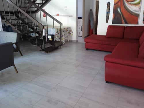 a living room with a red couch and a staircase at My Beach Villa in Port Dickson