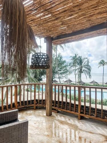 a porch with a view of the beach and the ocean at Villa Upendo with pool, Zanzibar in Pingwe
