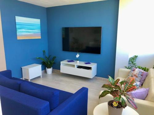 a blue living room with a couch and a tv at Vistas Mar Playa Las Canteras primera línea Wifi in Las Palmas de Gran Canaria
