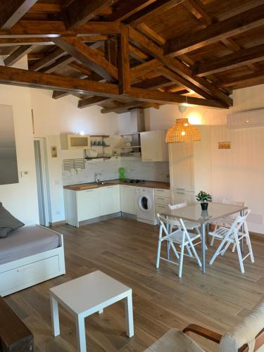 a living room with a table and a kitchen at Chalet al Mare in Civitavecchia