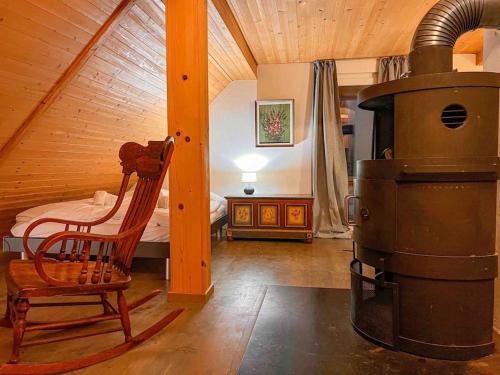 a room with a wood stove and a chair and a bed at Waterfall View in Kandersteg