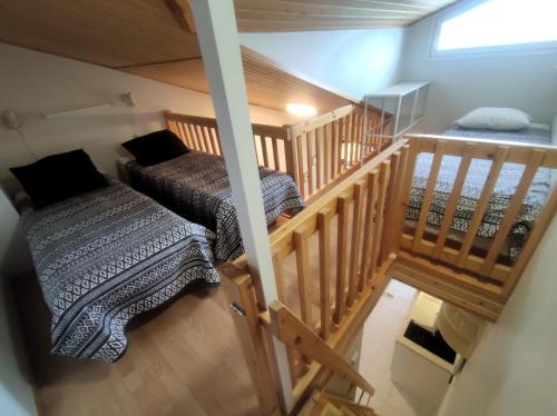 a attic room with two beds and a staircase at Leviloma - 27m2 B - Levi huoneisto loma-asunto Levistar majoitus - Levi apartment Levistar accommodation in Levi