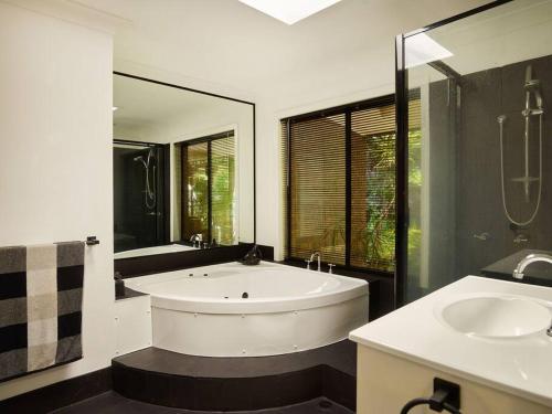 a bathroom with a large tub and two sinks at Bushland retreat in Gold Coast