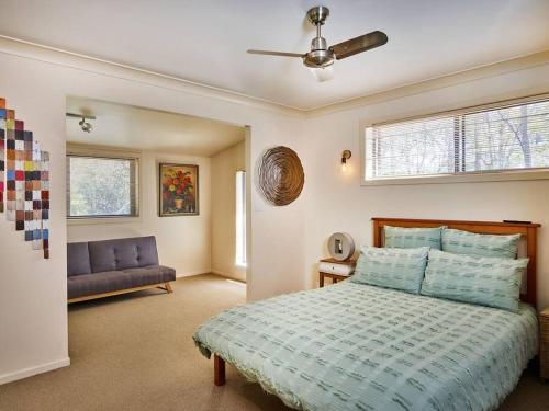 a bedroom with a bed and a ceiling fan at Bushland retreat in Gold Coast