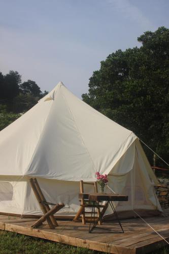 a white tent with a table and flowers in it at Lagom Village (Glamping Site) in Hanoi