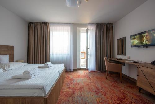 een hotelkamer met een bed en een bureau met een computer bij Wellness Hotel Vinnay in Vinné