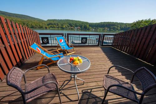 a wooden deck with chairs and a table with a bowl of fruit at Wellness Hotel Vinnay in Vinné
