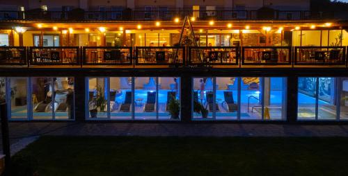 a building with people sitting in chairs at night at Wellness Hotel Vinnay in Vinné