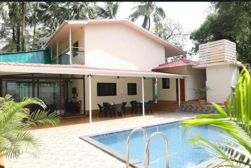 a house with a swimming pool in front of it at SAVI 4BHK VILLA ALIBAUG in Alibaug