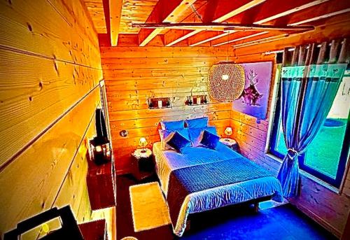 une chambre avec un lit dans une pièce en bois dans l'établissement Chalet Le Havre DU SOTRÈ Sauna et SPA, à Gérardmer